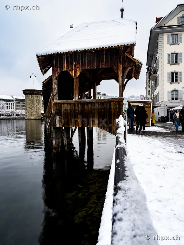 Snow-covered entrance of the wooden Chapel Bridge in Lucerne on the Reuss river