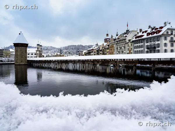 The Chapel Bridge and the old town of Lucerne in winter with snow.
