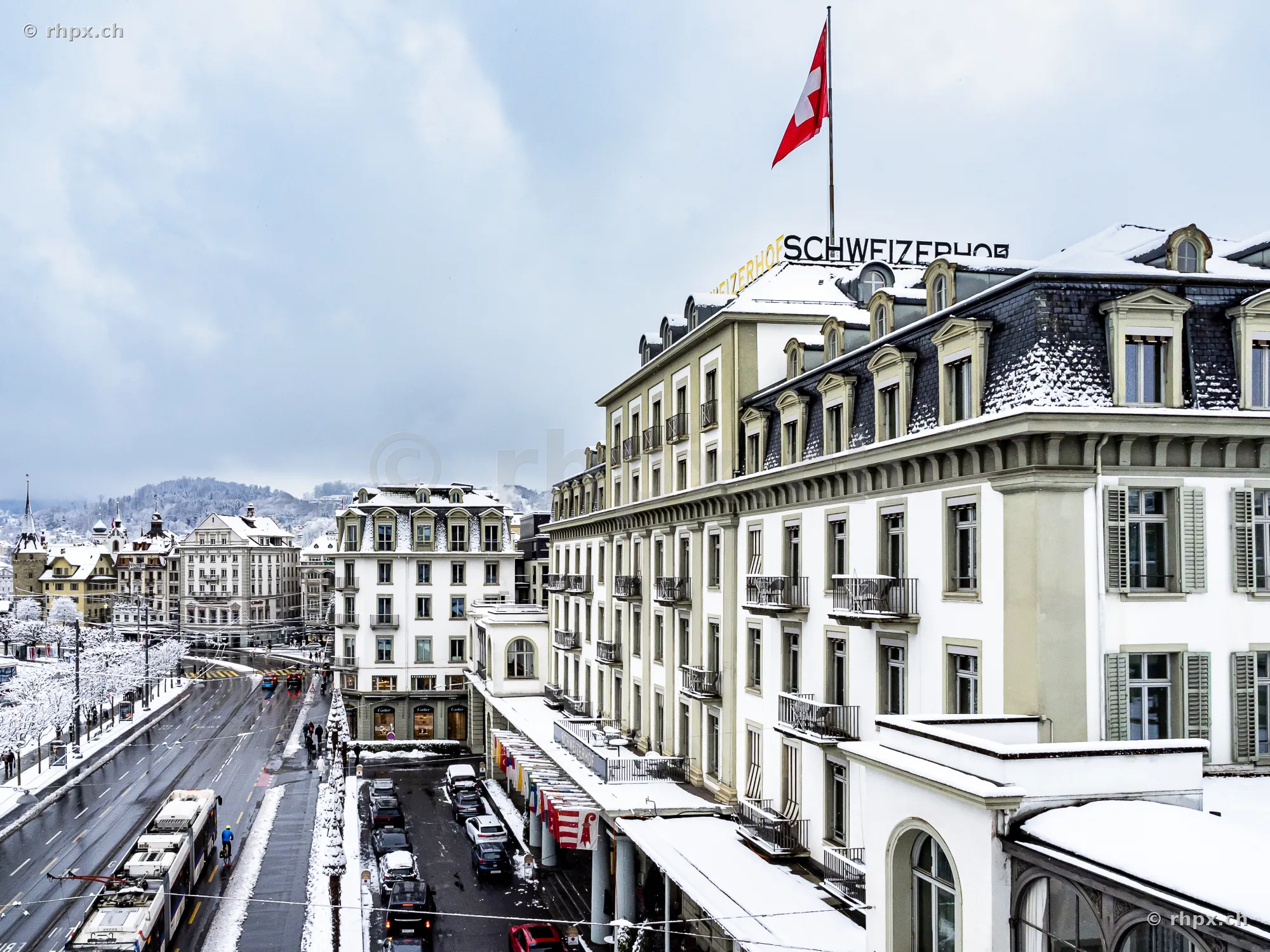 Blick von oben auf das schneebedeckte Hotel Schweizerhof in Luzern.