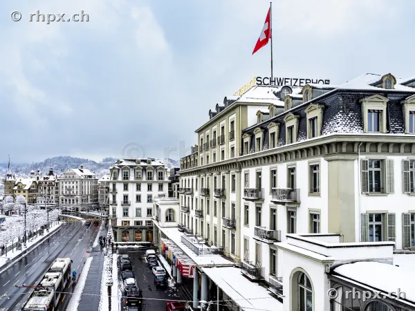 Blick von oben auf das schneebedeckte Hotel Schweizerhof in Luzern.