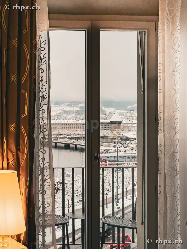 Blick aus einem Hotelzimmerfenster auf die winterliche Reuss und die Kapellbrücke in Luzern