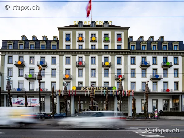 Fassade des Hotel Schweizerhof Luzern mit bunten Fasnachtskugeln und Figuren