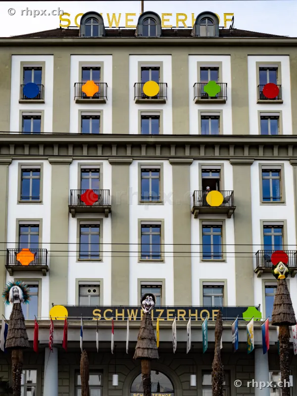 Facade of Hotel Schweizerhof in Lucerne with colorful decorations on the balconies