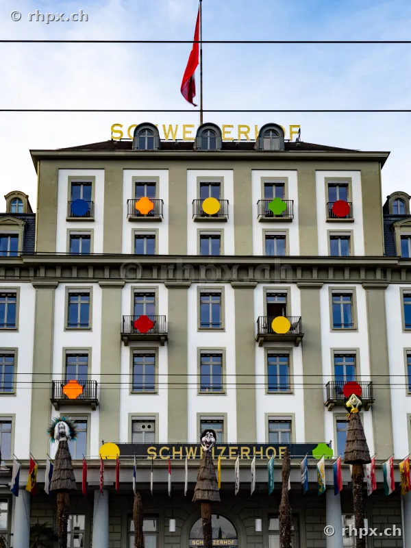 Fassade des Hotel Schweizerhof in Luzern mit farbigen Kreis-Symbolen an den Balkonen