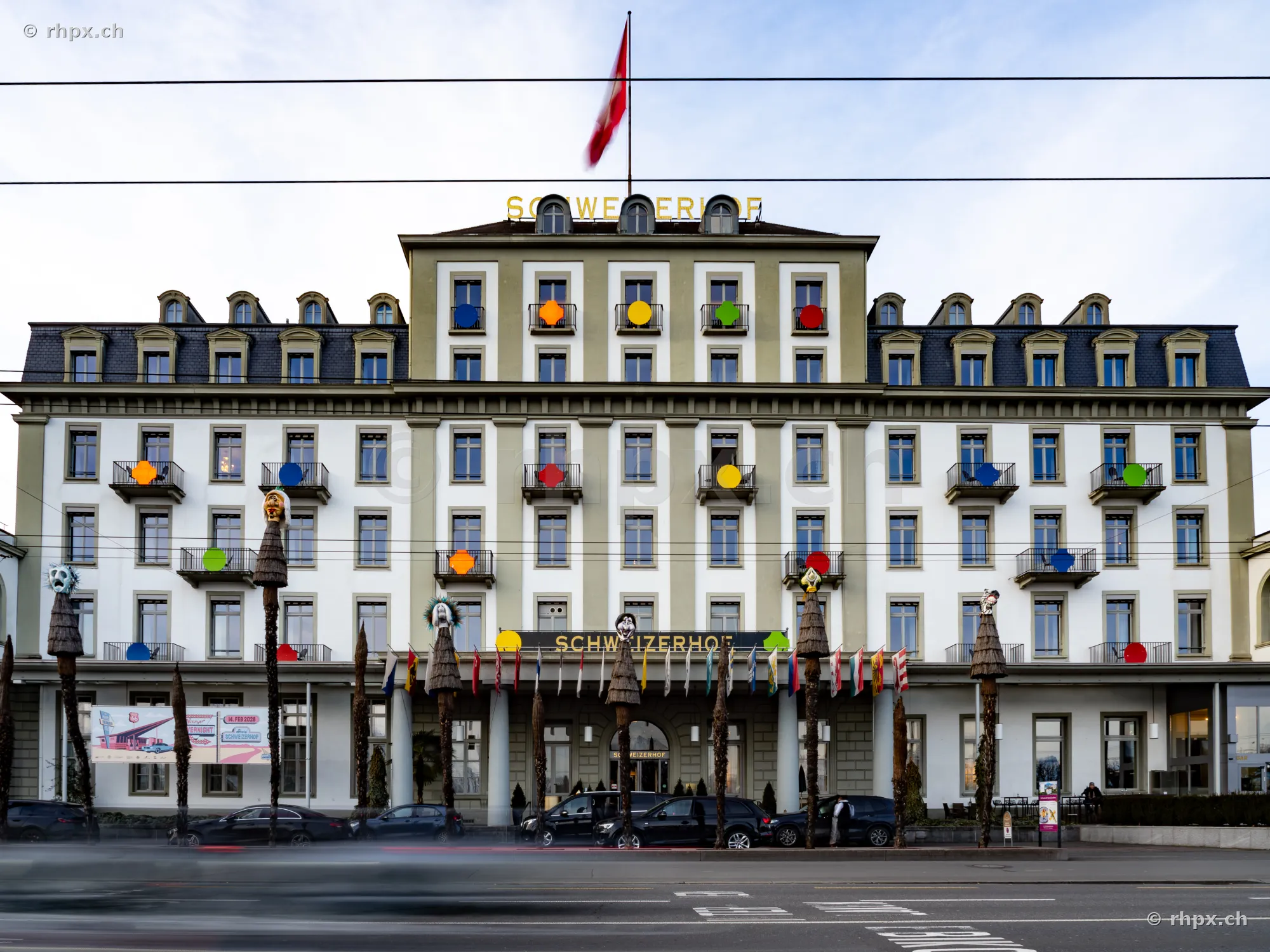 Frontalansicht des Hotels Schweizerhof Luzern mit bunten Balkonakzenten