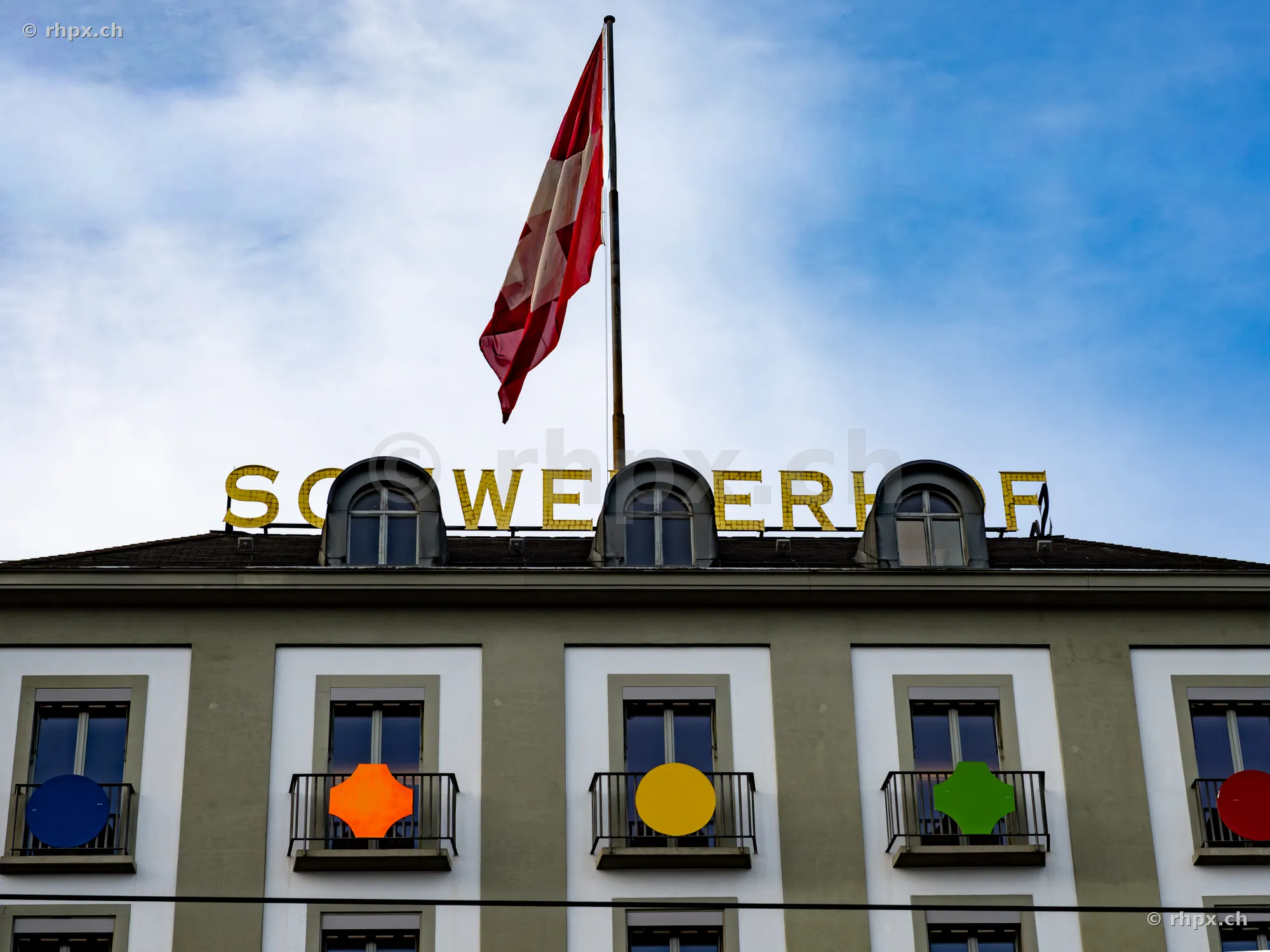 Fassade des Hotels Schweizerhof in Luzern mit wehender Schweizer Flagge auf dem Dach.