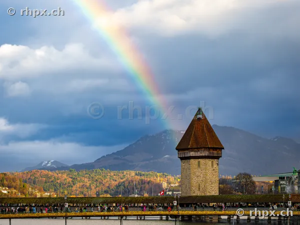 Chapel Bridge and Water Tower in Lucerne with a rainbow in a cloudy sky