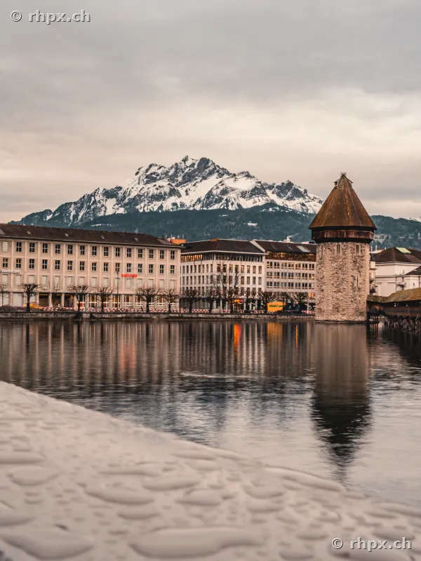 Wasserturm der Kapellbrücke an der Reuss mit dem schneebedeckten Pilatus im Hintergrund