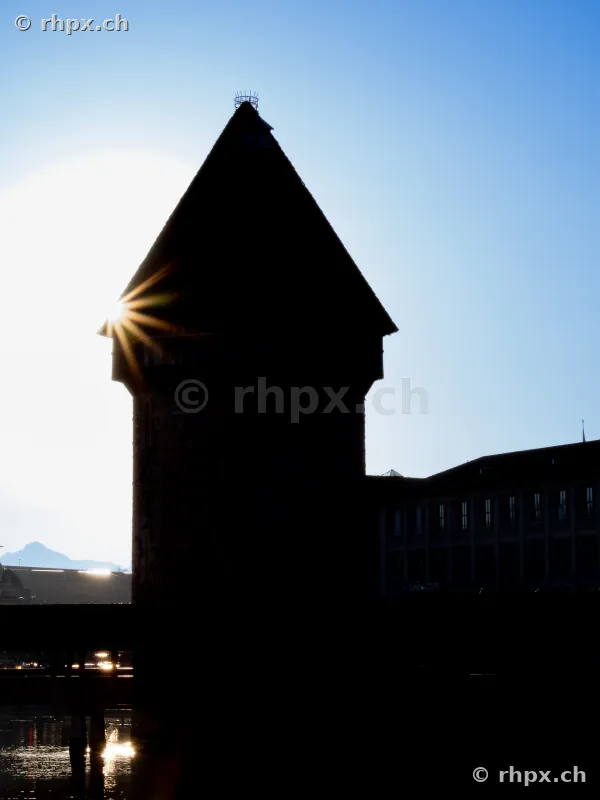 Silhouette of the Wasserturm in Lucerne against the sun