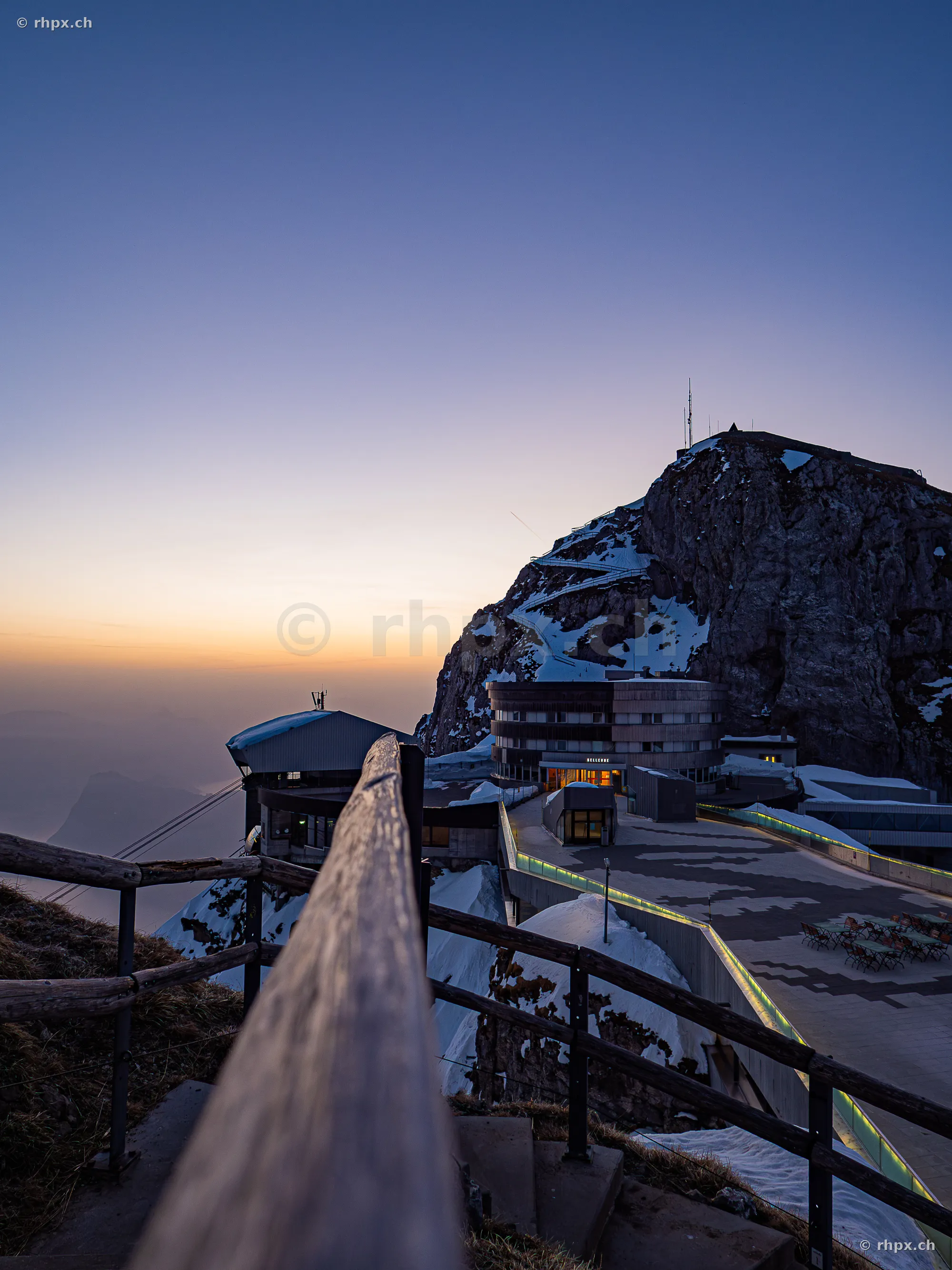 View from stairs onto the Hotel Pilatus Kulm and the mountain peak at sunset.