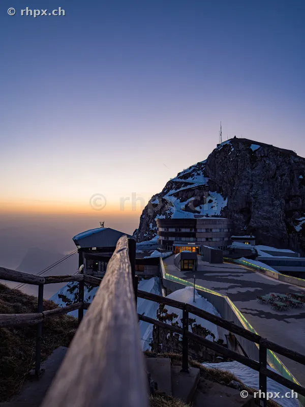 View from stairs onto the Hotel Pilatus Kulm and the mountain peak at sunset.