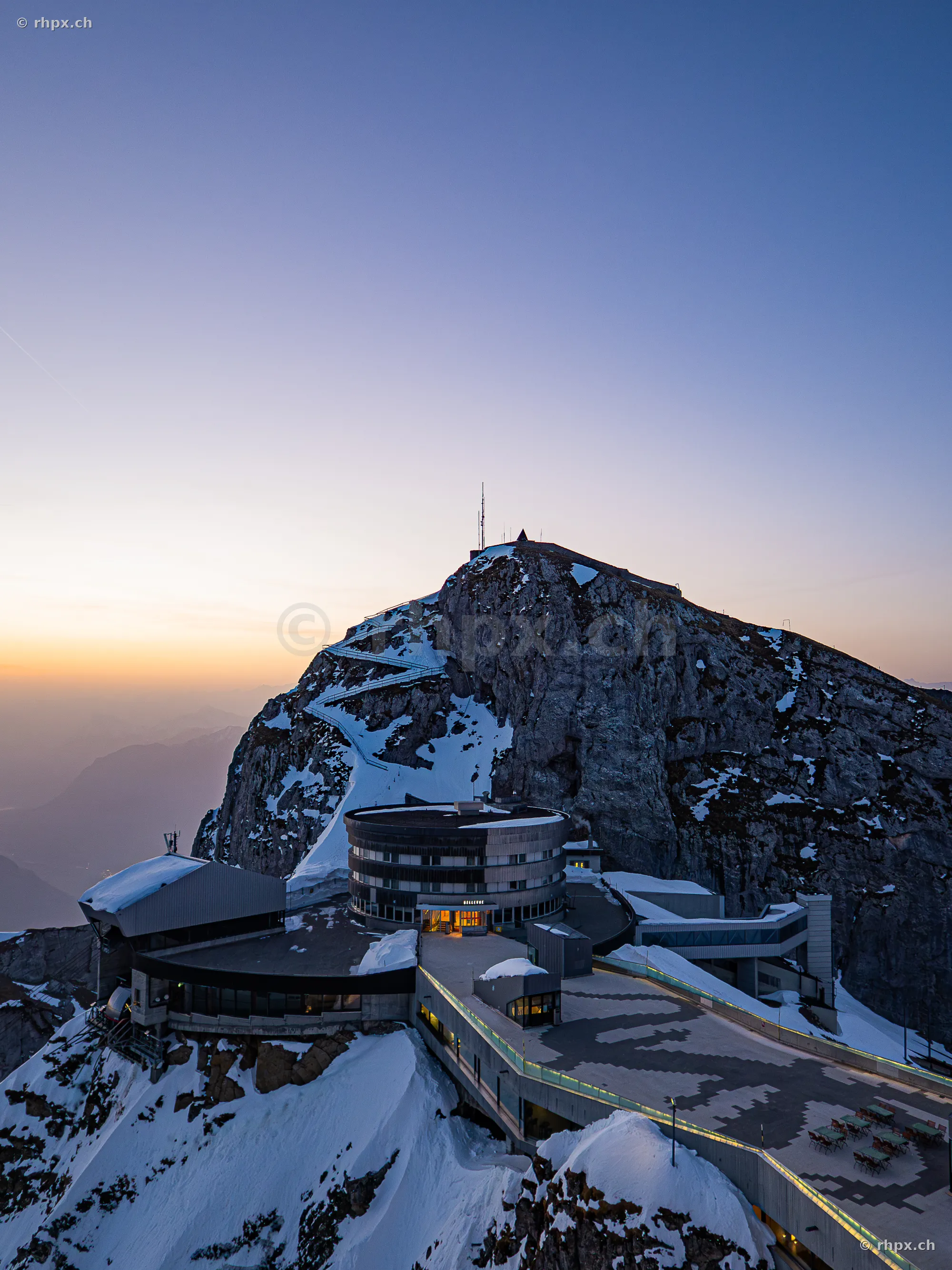 View of the Pilatus Kulm Hotel and mountain station in snow at sunrise