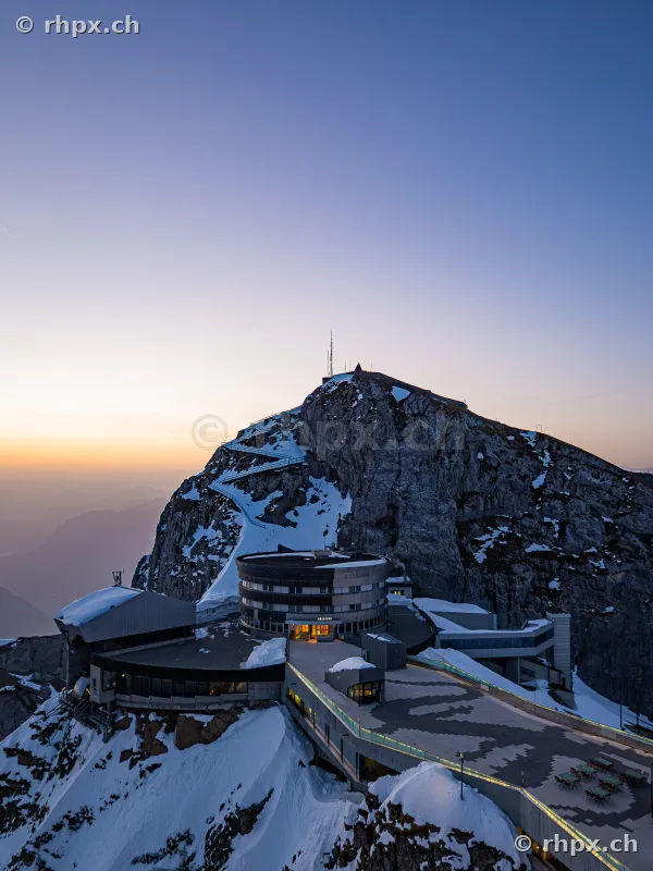 View of the Pilatus Kulm Hotel and mountain station in snow at sunrise
