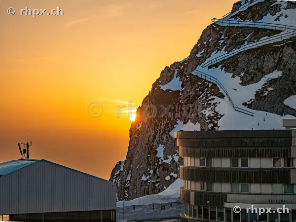 Sunset behind the rock face on Mount Pilatus with Hotel Bellevue in the foreground.