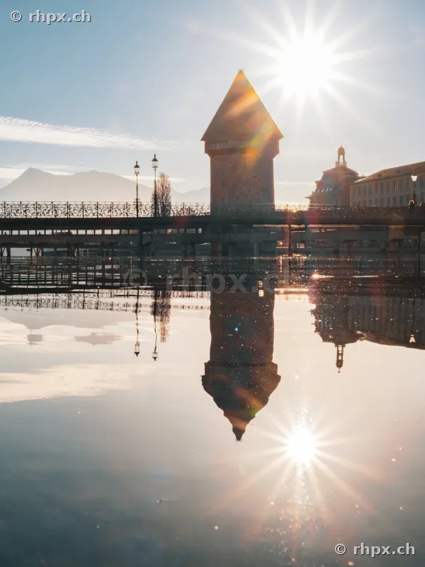 Wasserturm and Chapel Bridge in Lucerne with reflection in the water at sunrise