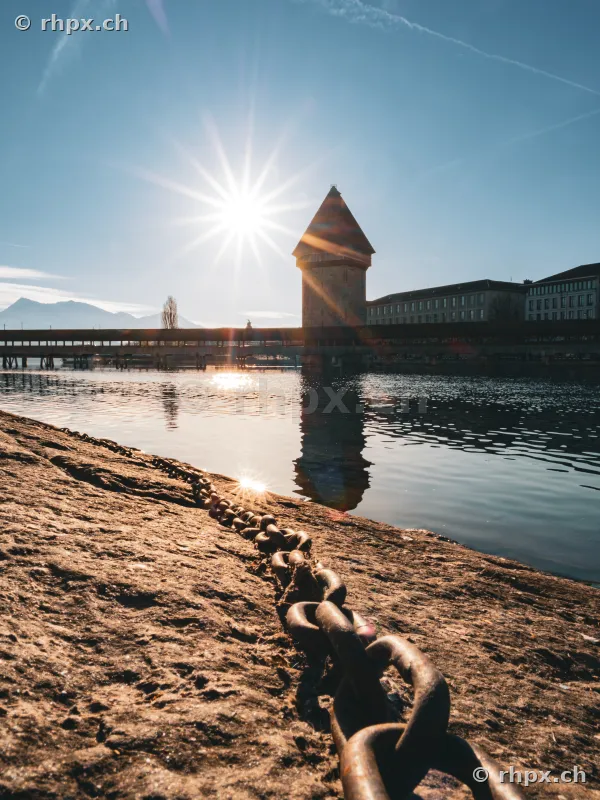 View across a quay chain towards the Chapel Bridge and Water Tower in Lucerne