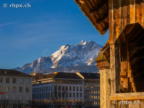 Wooden structure of the Chapel Bridge in the foreground with Mount Pilatus in the background in Lucerne