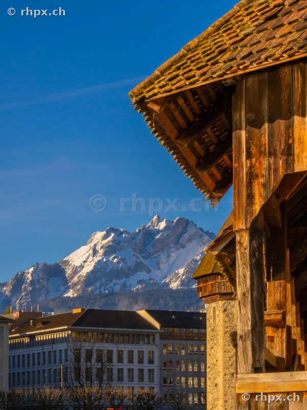 Detail of the wooden Chapel Bridge with snow-covered Mount Pilatus in the background in Lucerne