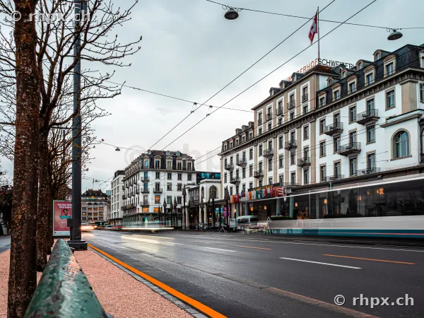 Hotel Schweizerhof in Luzern bei trübem Licht mit vorbeifahrendem Tram