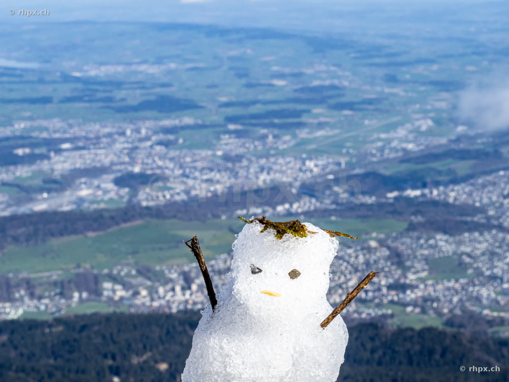 A small snowman made of snow on top of Mount Pilatus overlooking the Swiss plateau