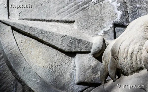 Detail view of a spear carved in stone at the Lion Monument in Lucerne