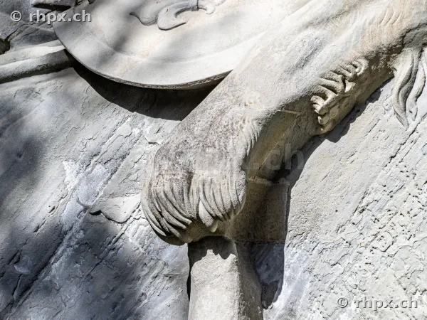 Close-up of the stone lion paw at the Lion Monument in Lucerne with side lighting