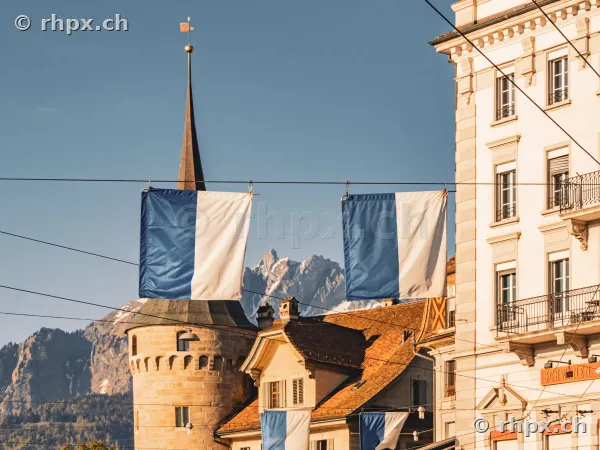 Two blue and white Lucerne cantonal flags hanging in front of Mount Pilatus and historic buildings in Lucerne Old Town