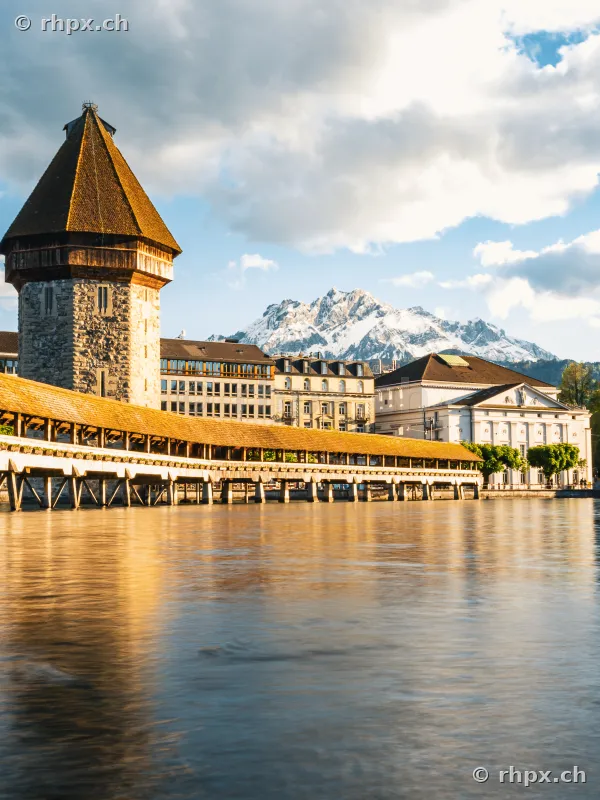 Chapel Bridge and Water Tower in Lucerne with snow-covered Mount Pilatus in the background