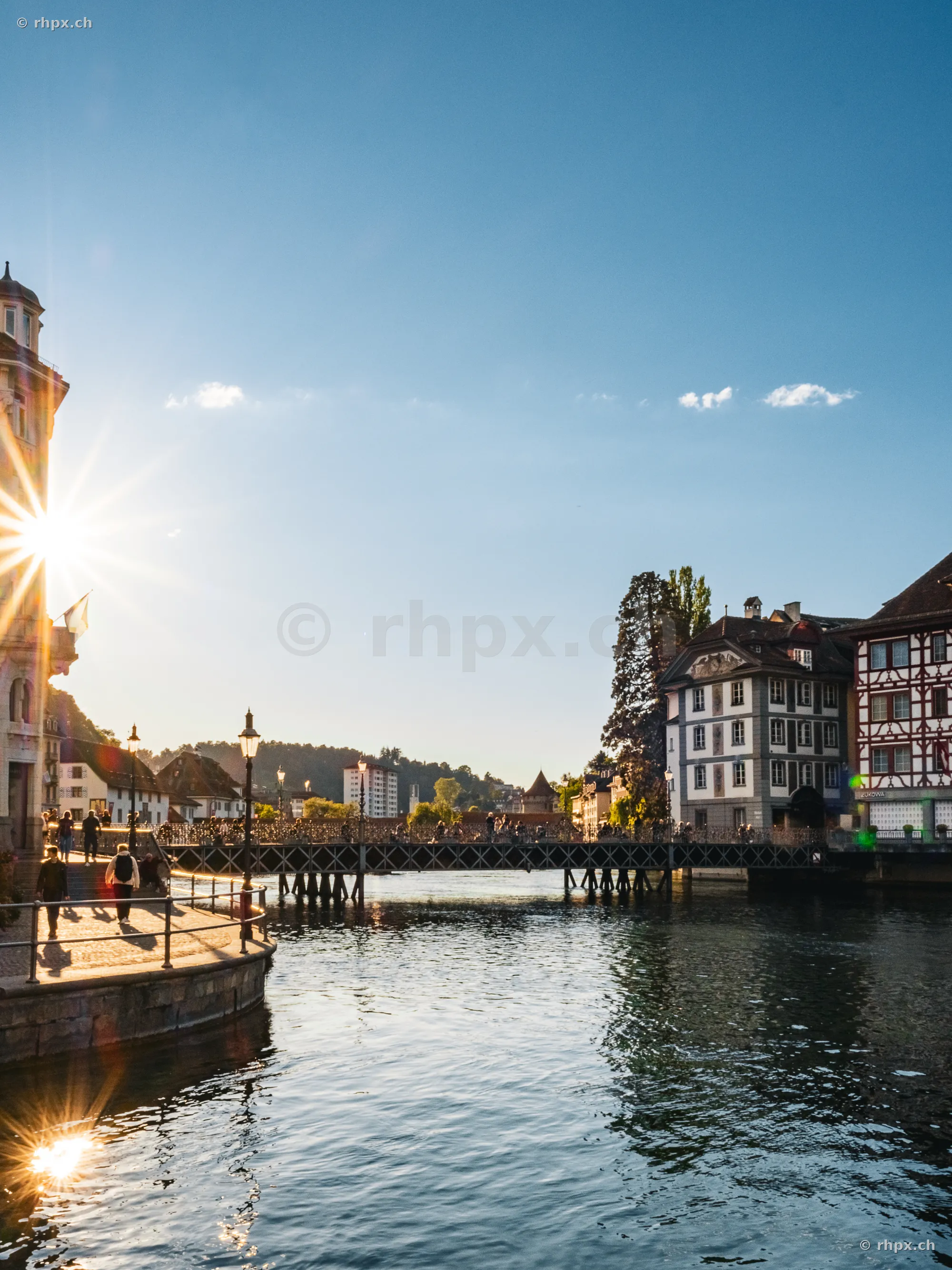 The Reuss river in Lucerne with the Rathaussteg bridge in the backlight of the setting sun