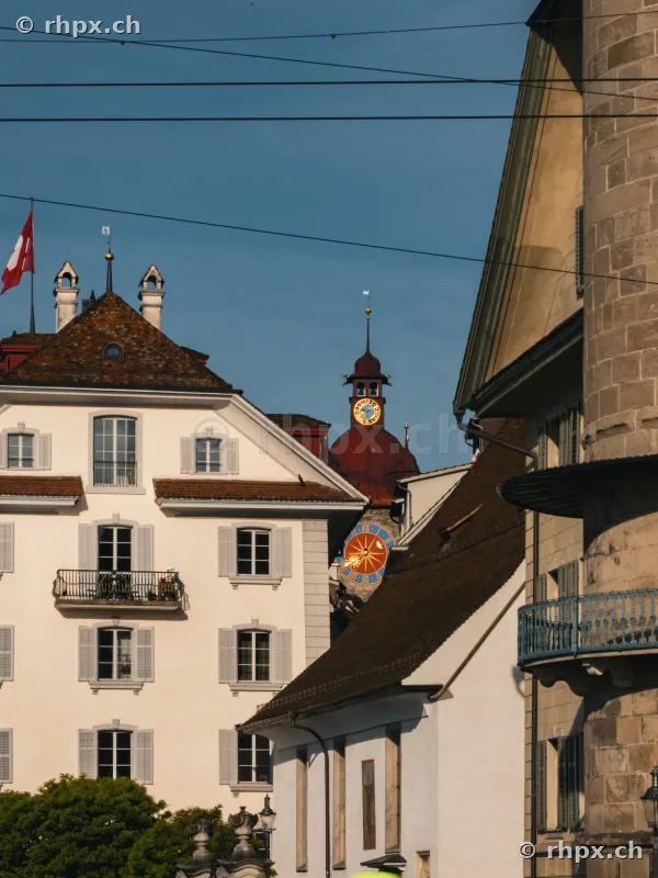 Historic buildings and church tower top in the old town of Lucerne in clear daylight.