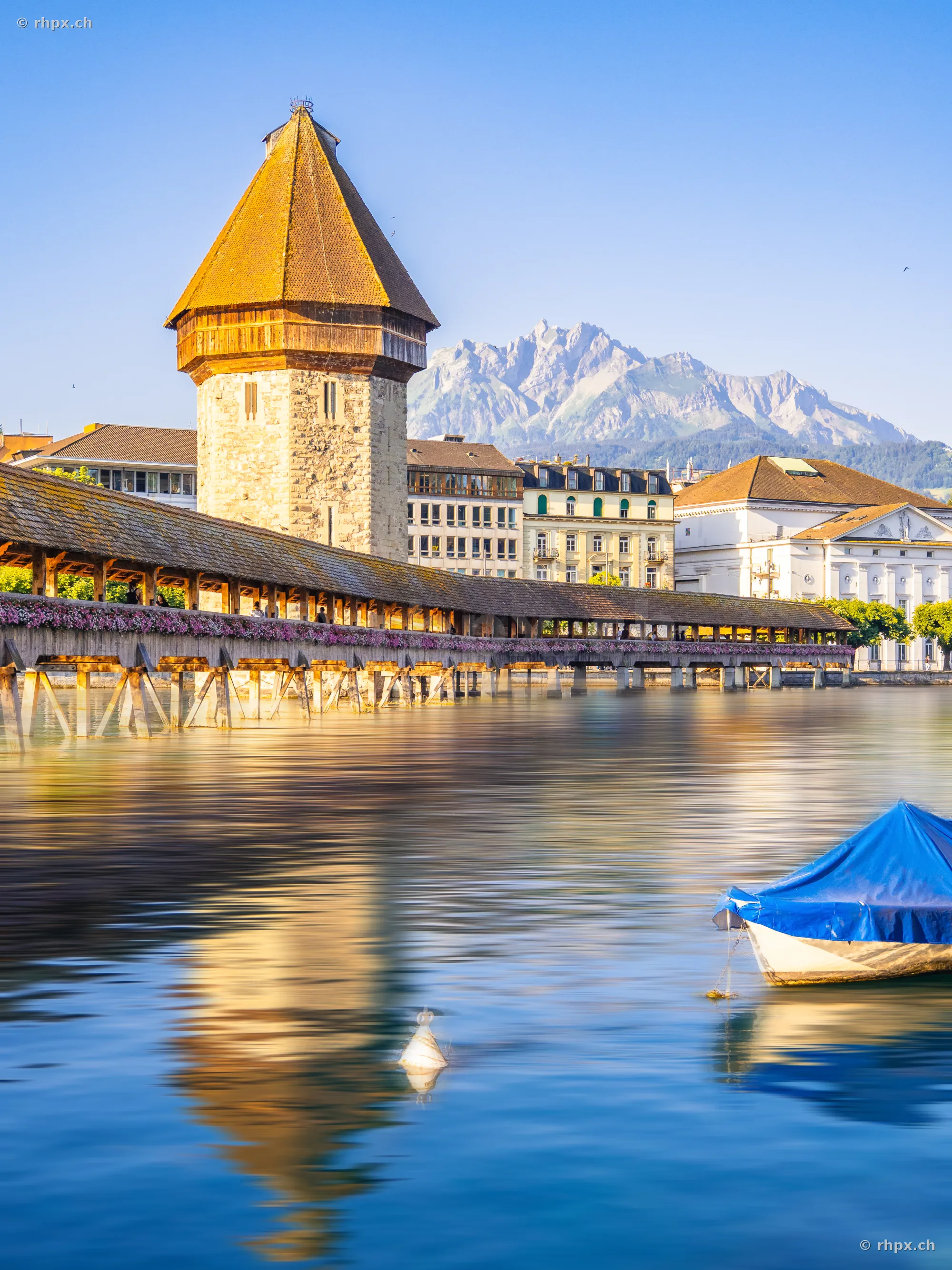 Chapel Bridge with water tower in Lucerne in front of Mount Pilatus at dawn