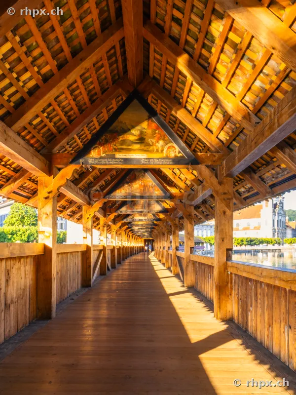 View through the wooden Chapel Bridge in Lucerne in the morning sunlight