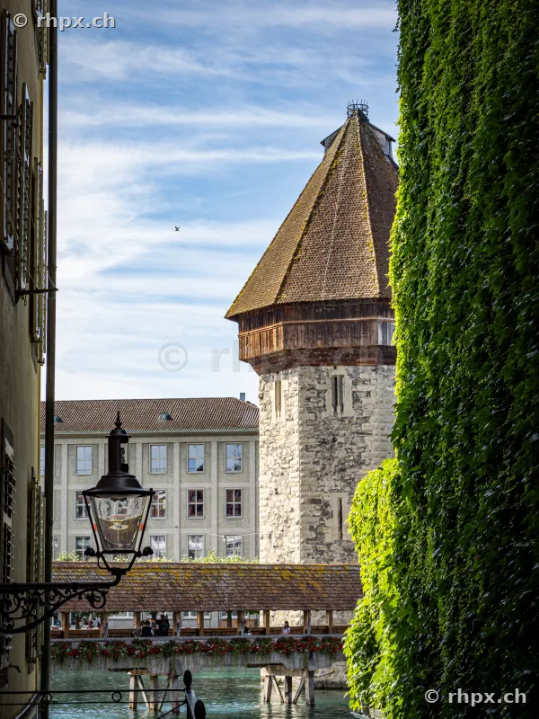 View through a narrow alley of the Wasserturm and Chapel Bridge in Lucerne