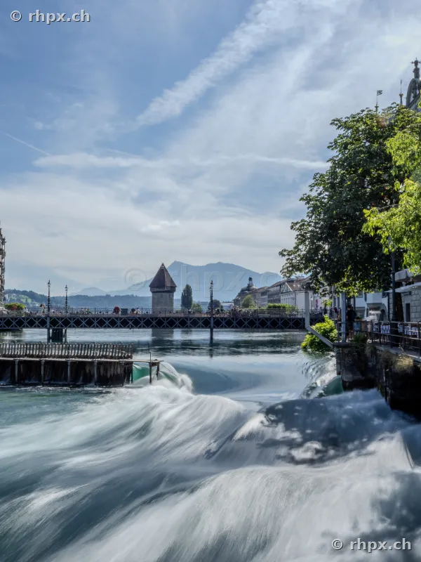 View of the Reuss weir and the Wasserturm in Lucerne on a sunny day.