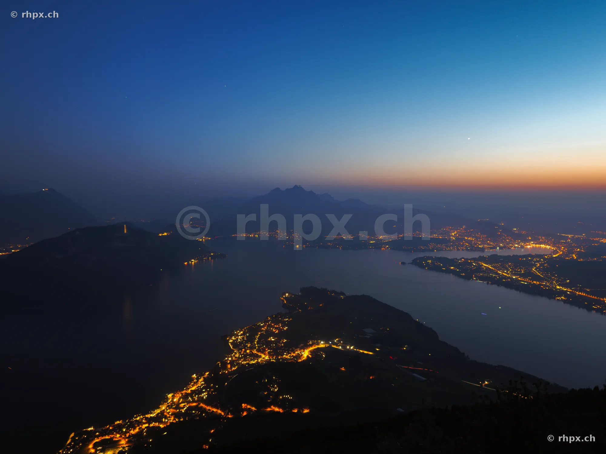 View of Lake Lucerne and Mount Pilatus with illuminated villages at night