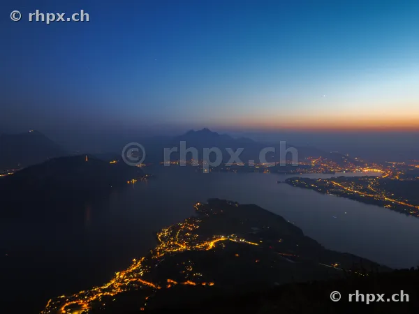 View of Lake Lucerne and Mount Pilatus with illuminated villages at night