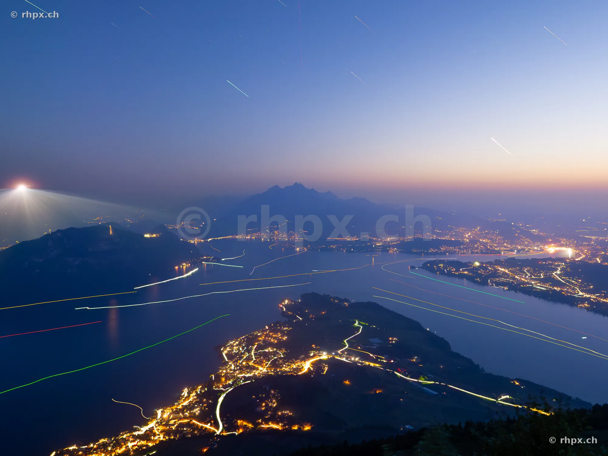 Night view of Lake Lucerne and Mount Pilatus with light trails from boats