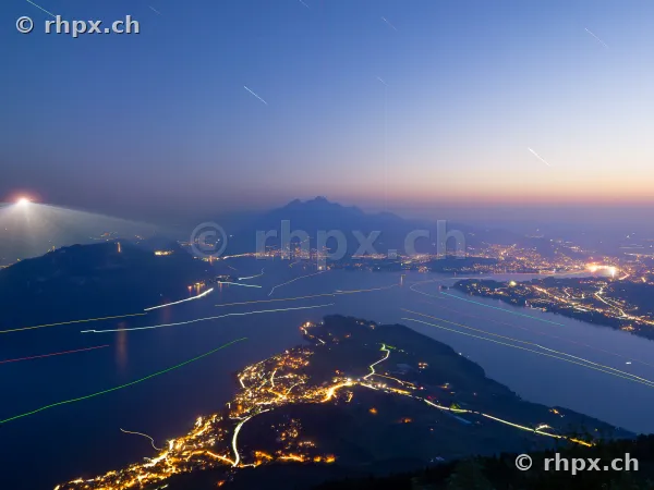 Night view of Lake Lucerne and Mount Pilatus with light trails from boats