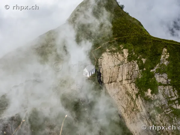 A small chapel on the rock massif of Mount Pilatus, surrounded by dense fog.