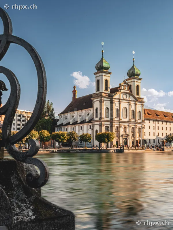 Jesuit Church in Lucerne with Reuss river in the foreground and wrought iron railing