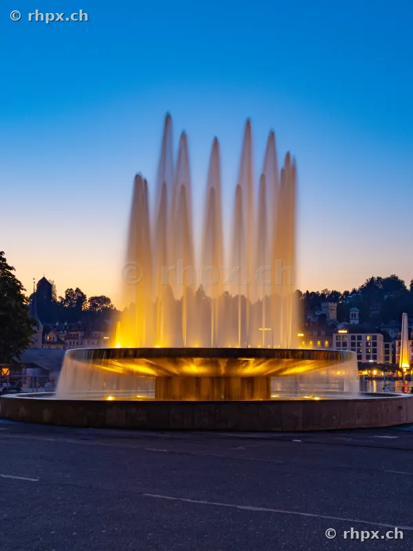 The illuminated fountain at the Lucerne lake basin at twilight