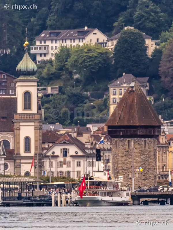 View of the Water Tower and Jesuit Church in Lucerne on Lake Lucerne with a passenger ship