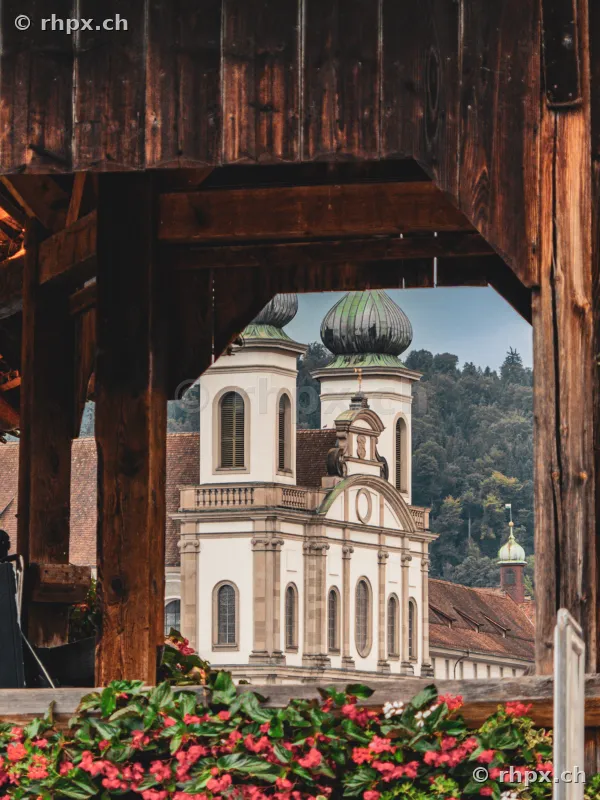 View through a wooden archway at the Jesuit Church in Lucerne with flowers