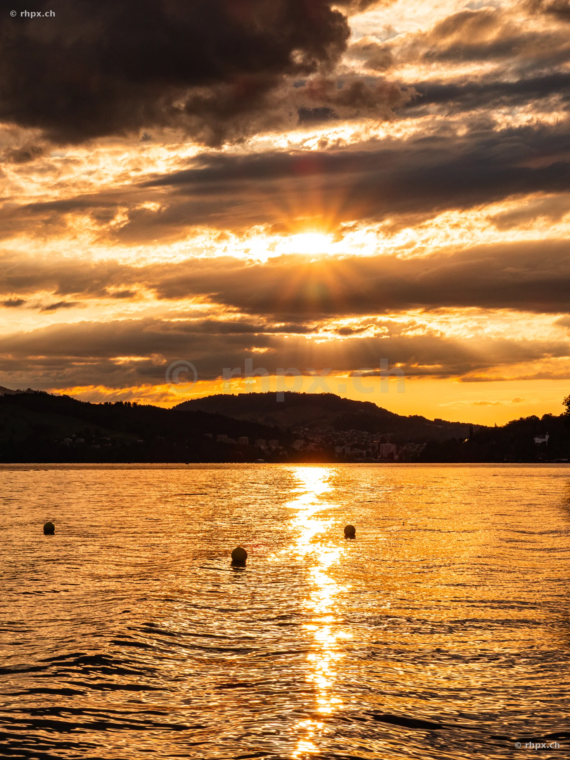 Golden sunset over Lake Lucerne with dark cloud formations