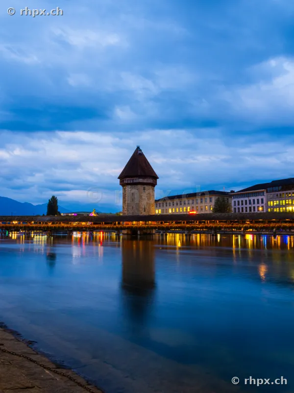 Chapel Bridge with Water Tower in Lucerne under a blue evening sky