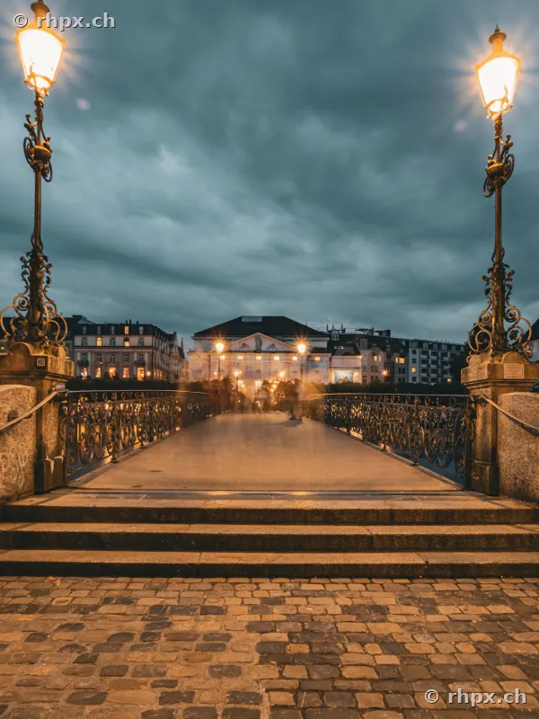 View across the Seebrücke bridge in Lucerne at dusk with street lamps in the foreground
