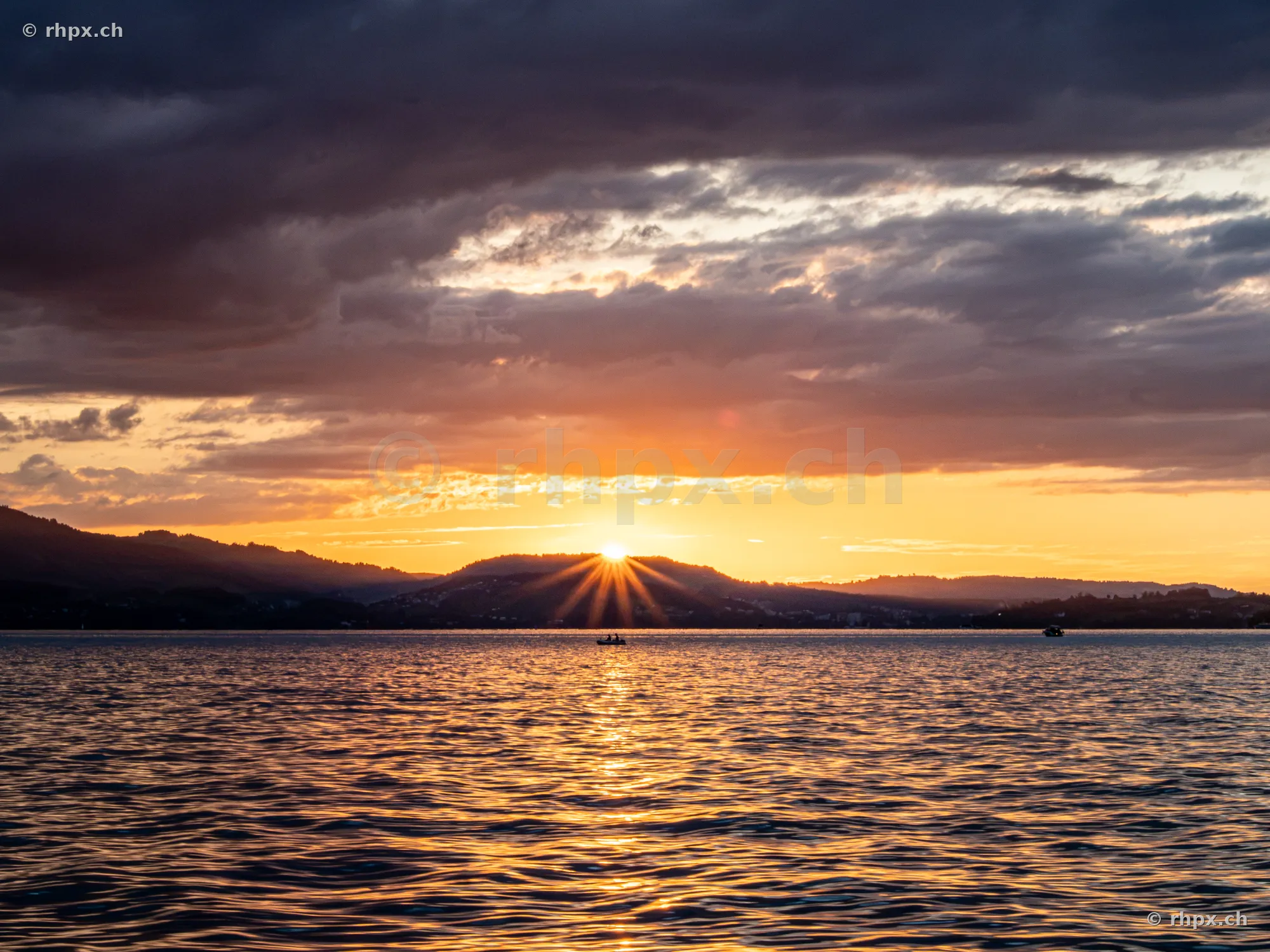 Die Sonne geht hinter den Hügeln über dem Vierwaldstättersee unter