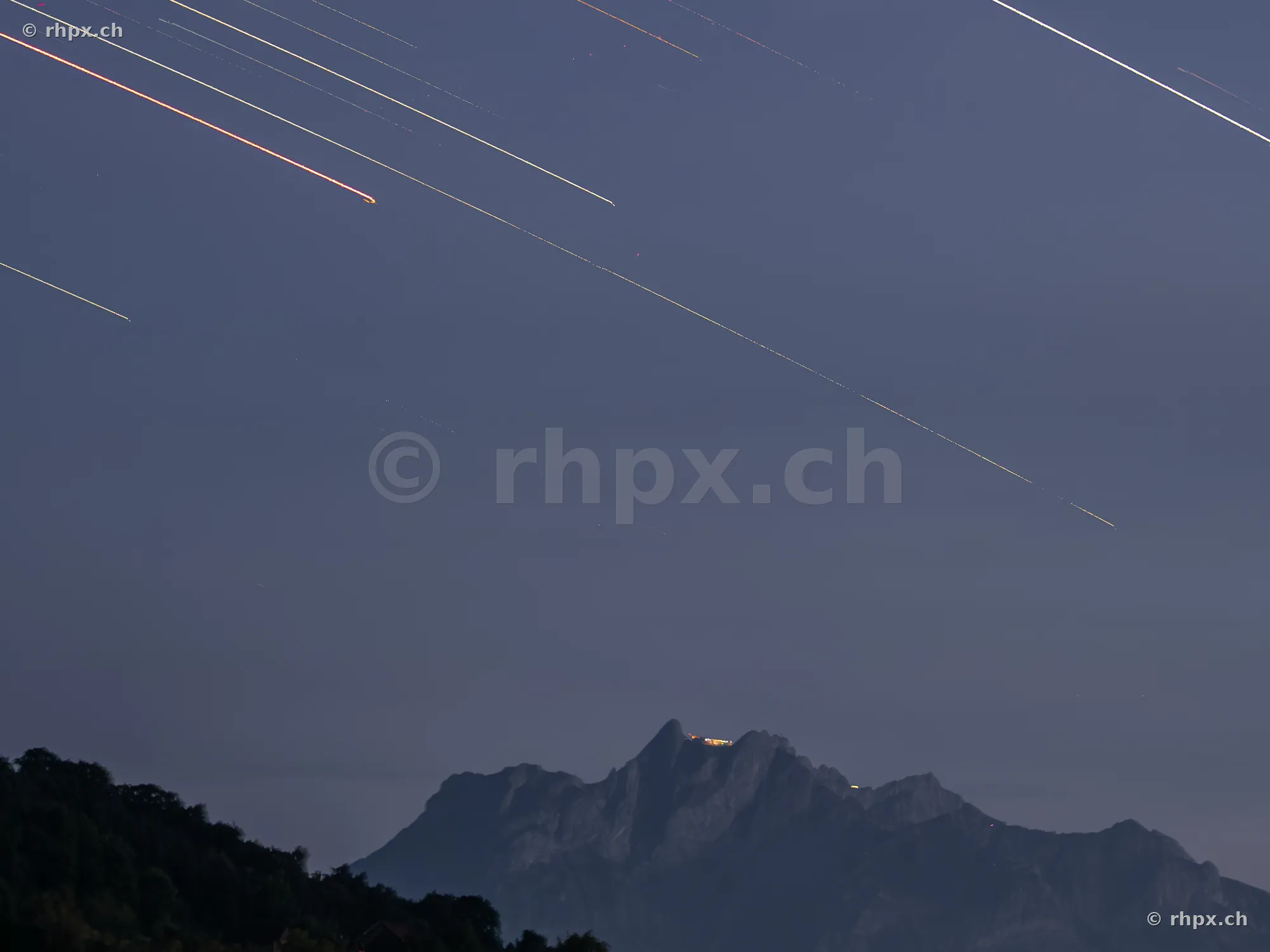 Long exposure of star trails above the dark Mount Pilatus massif in Central Switzerland.