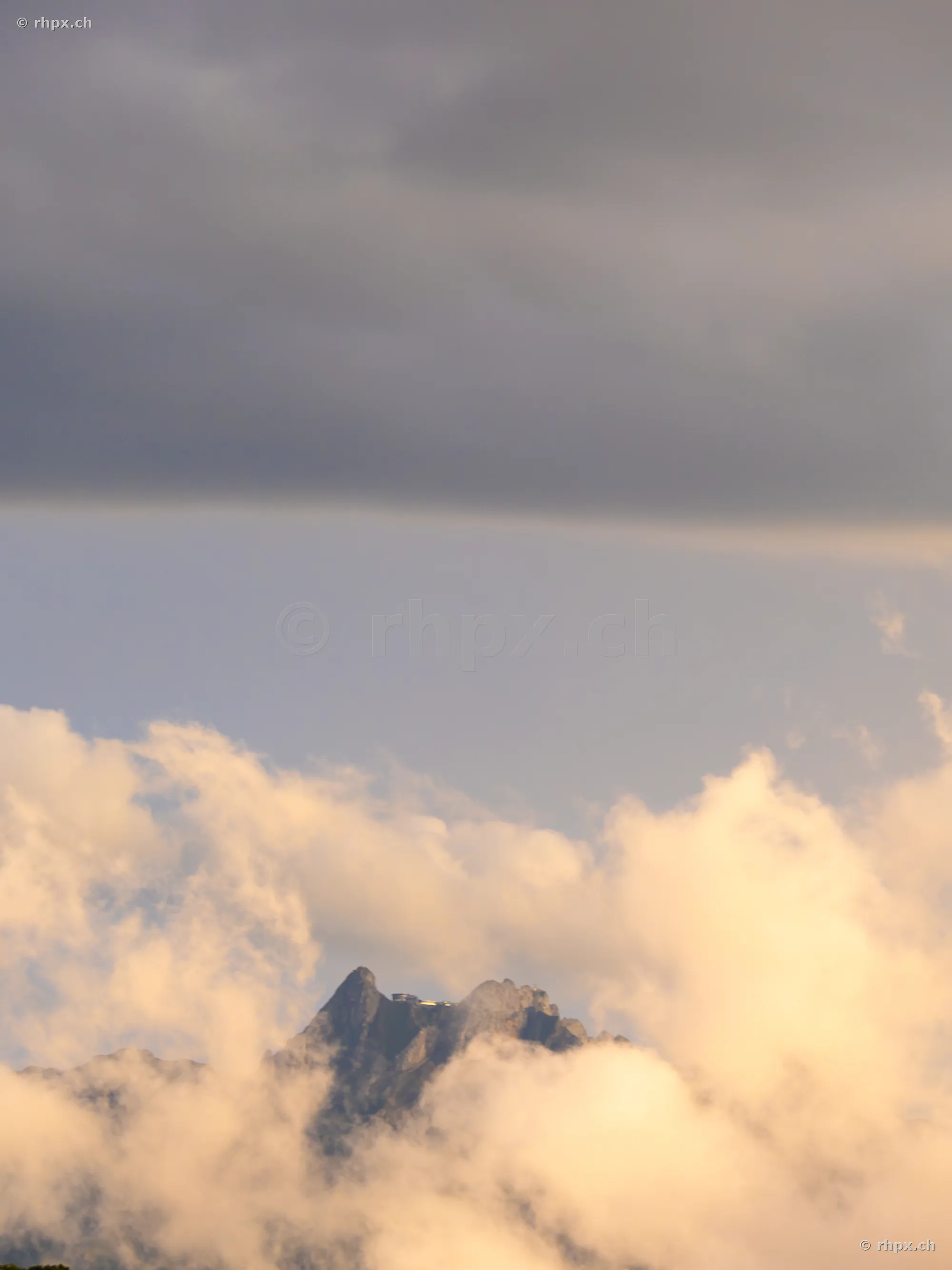 Der Gipfel des Pilatus umgeben von Wolken in warmem Licht