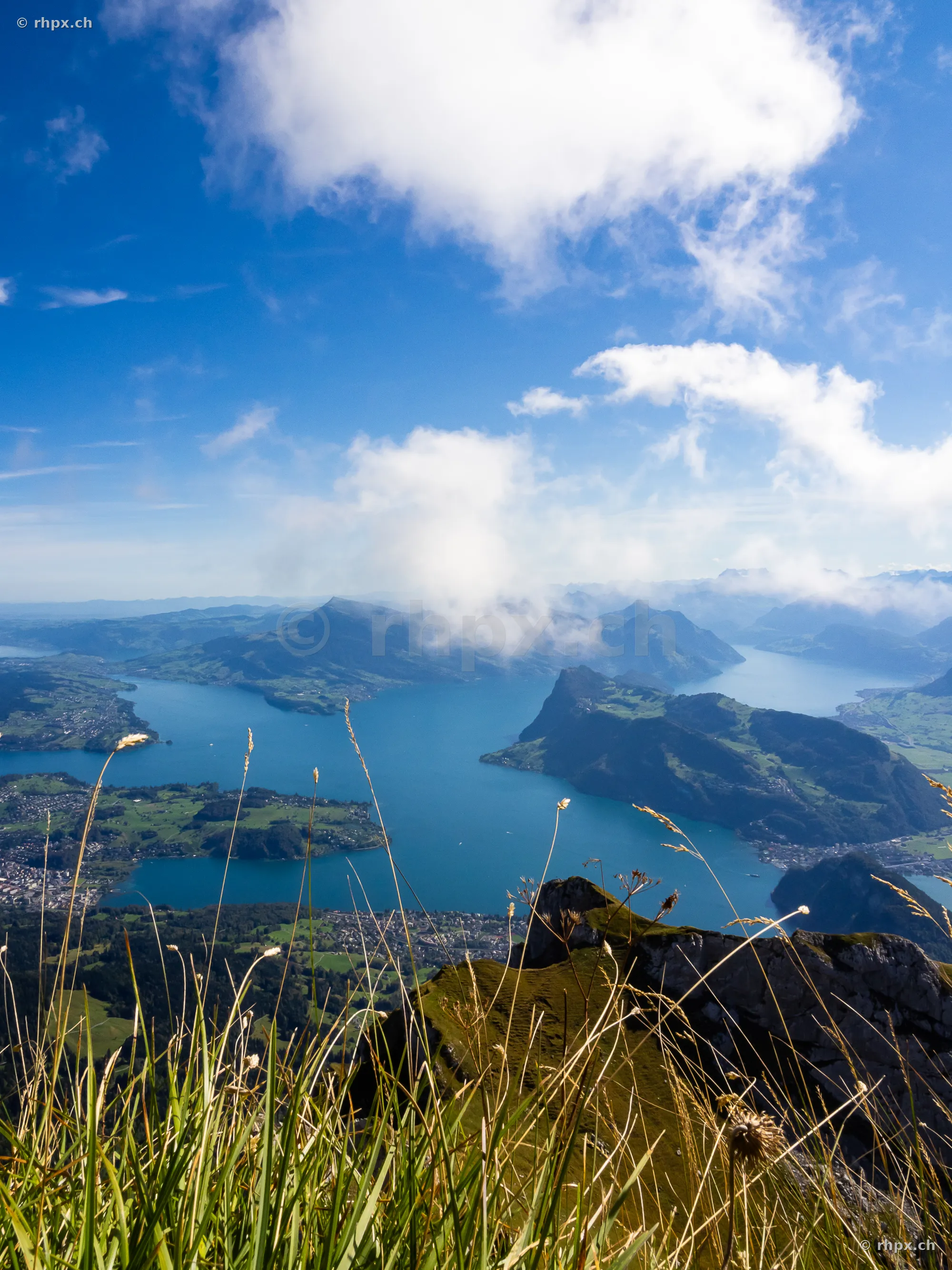 Blick vom Bergmassiv Pilatus auf den Vierwaldstättersee und umliegende Berge bei sonnigem Wetter